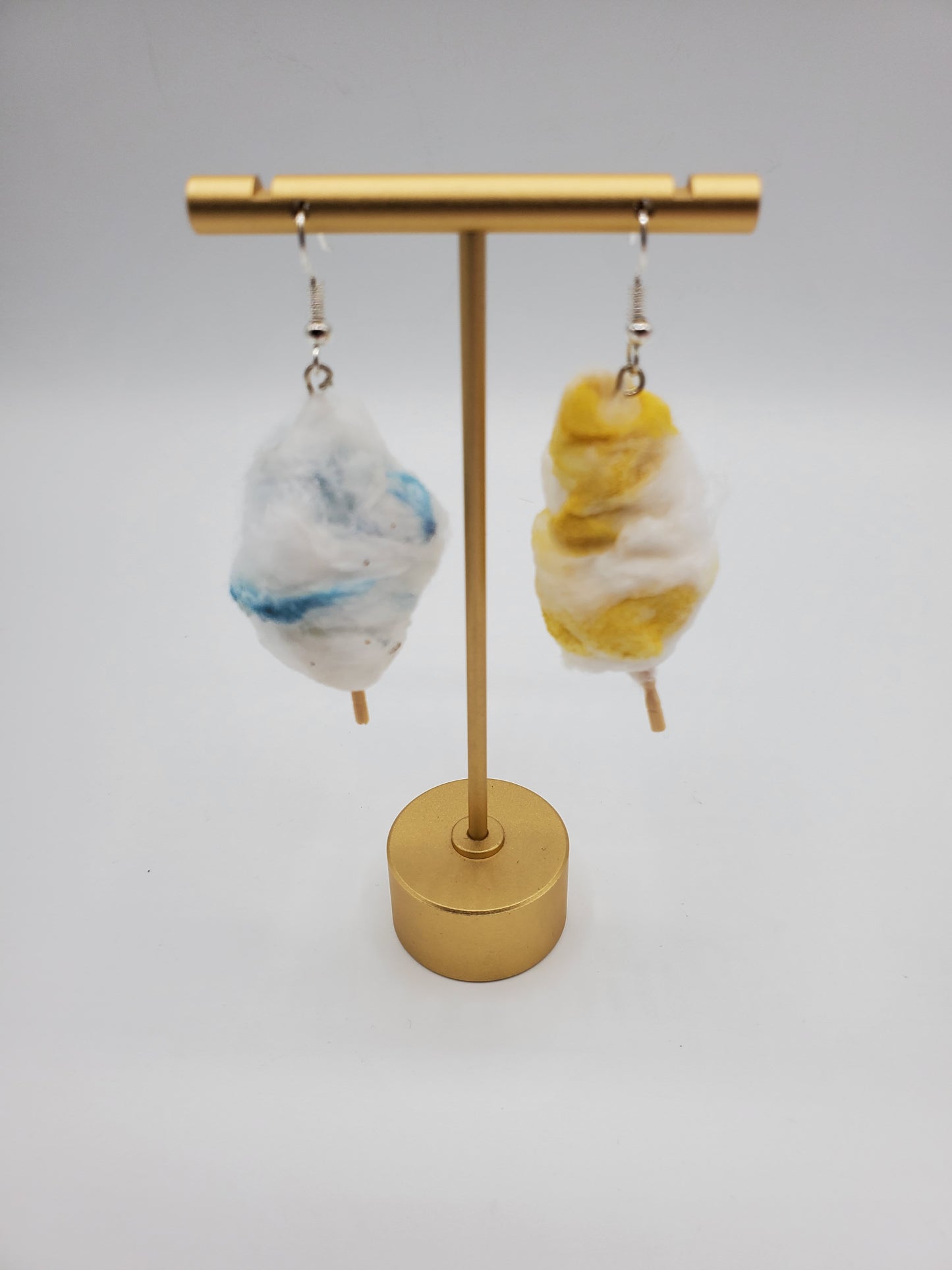 Chef Gina's Mini Food cotton candy earrings in blue and yellow displayed on gold stand