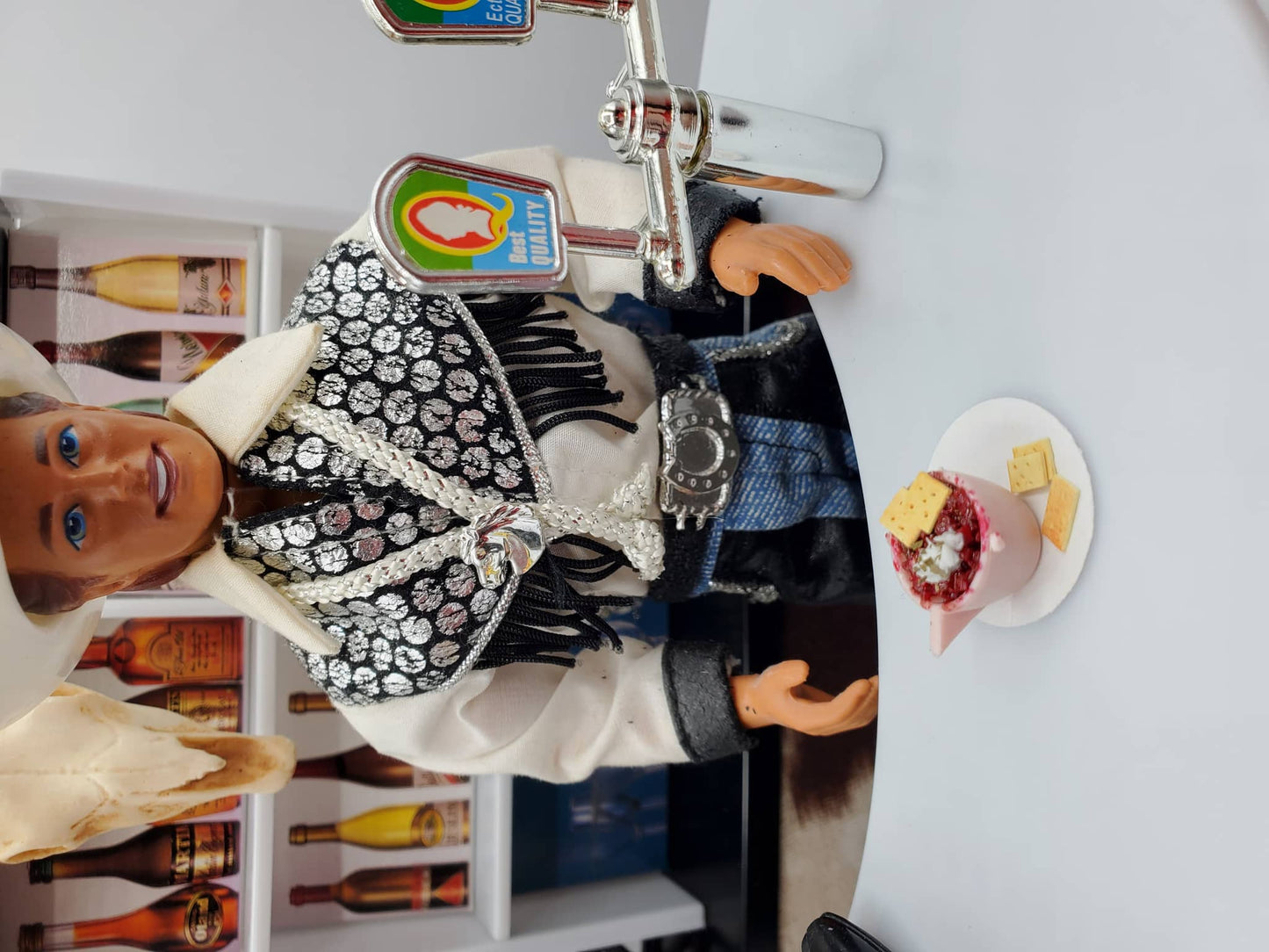Cup of Chili with Crackers For Dolls served in a miniature pink bowl on a white plate next to a cowboy doll at a bar