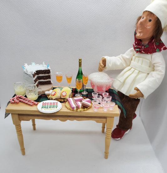 1:12 scale doll furniture wooden table with miniature holiday treats and drinks next to chef doll