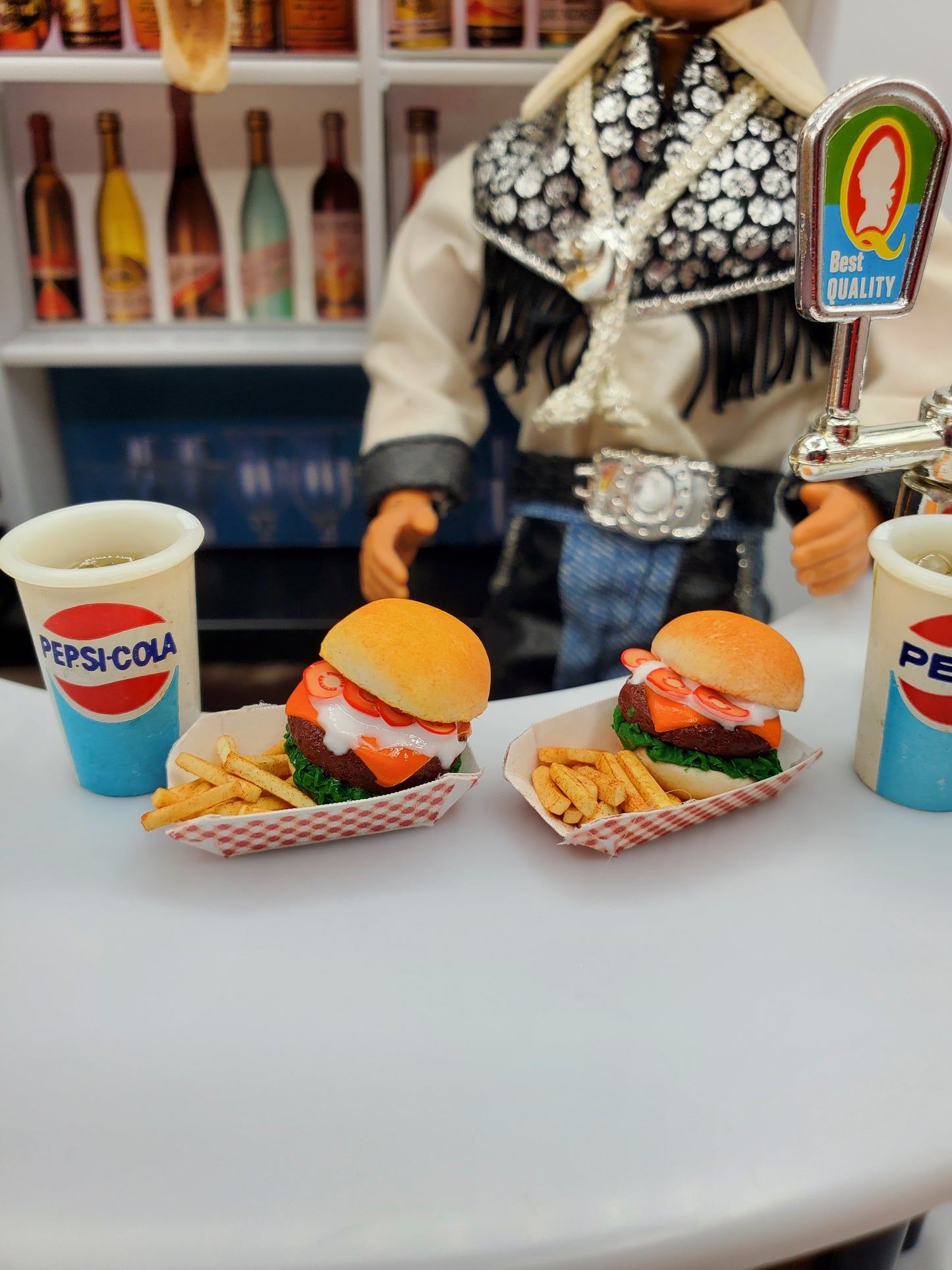Chef Gina's miniature bison burgers for dolls served with fries and Pepsi-Cola cups on a table