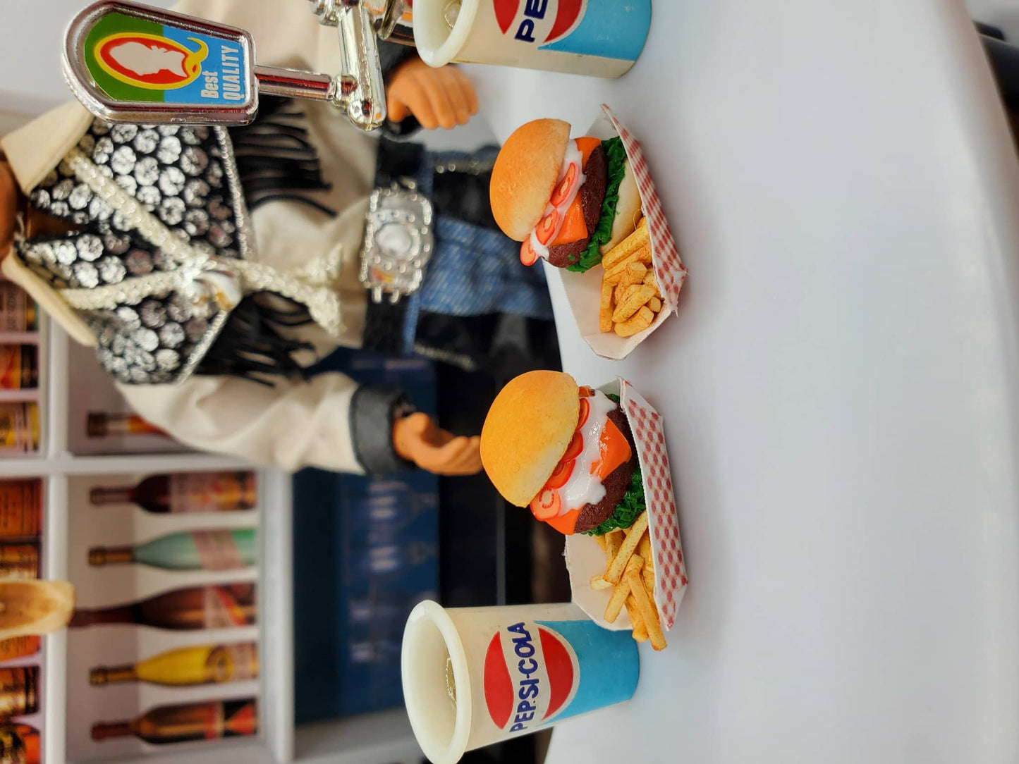 Chef Gina's miniature bison burgers for dolls served with fries and Pepsi-Cola cups on a table