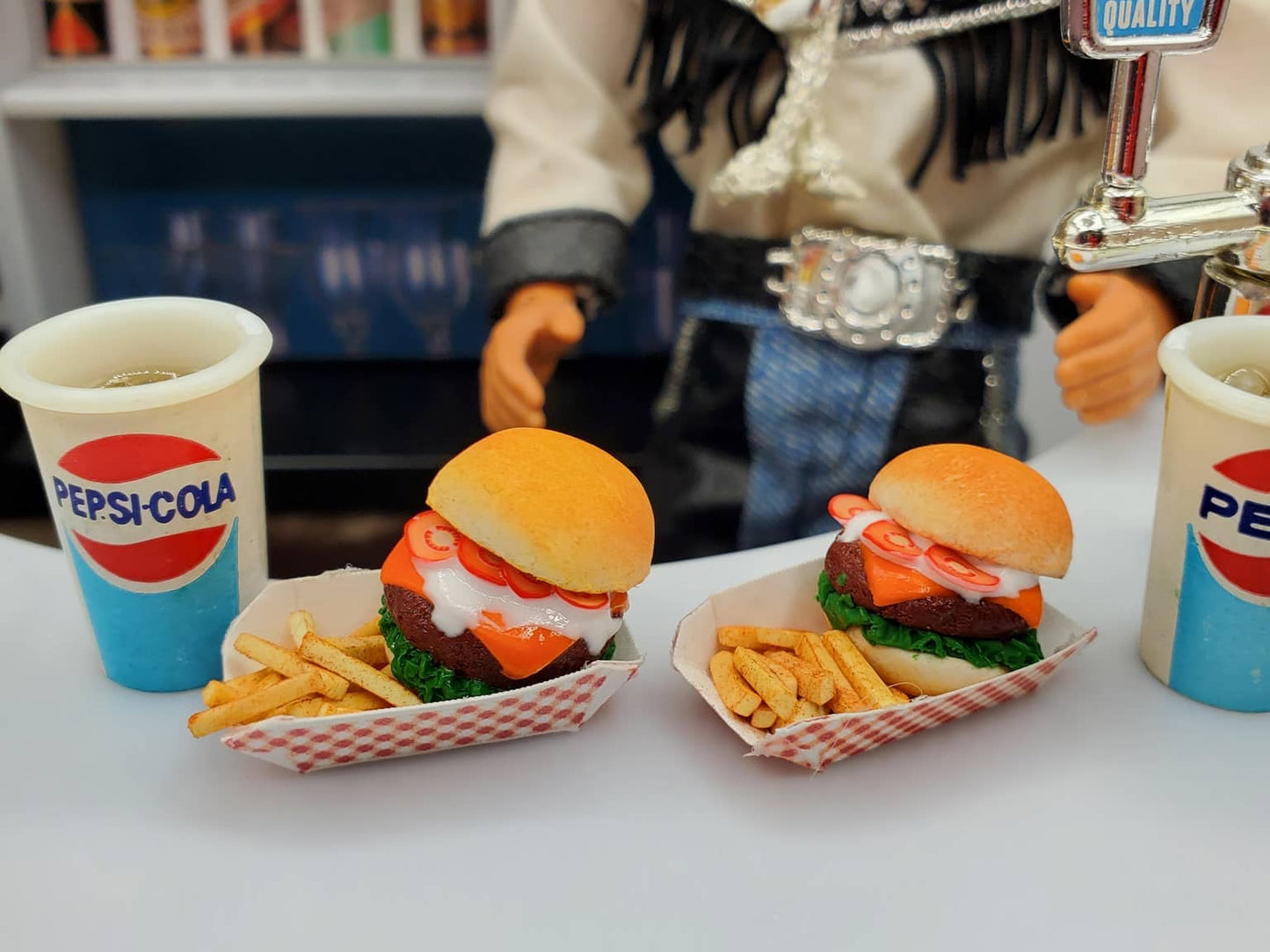 Chef Gina's miniature bison burgers for dolls served with fries and Pepsi-Cola cups on a table
