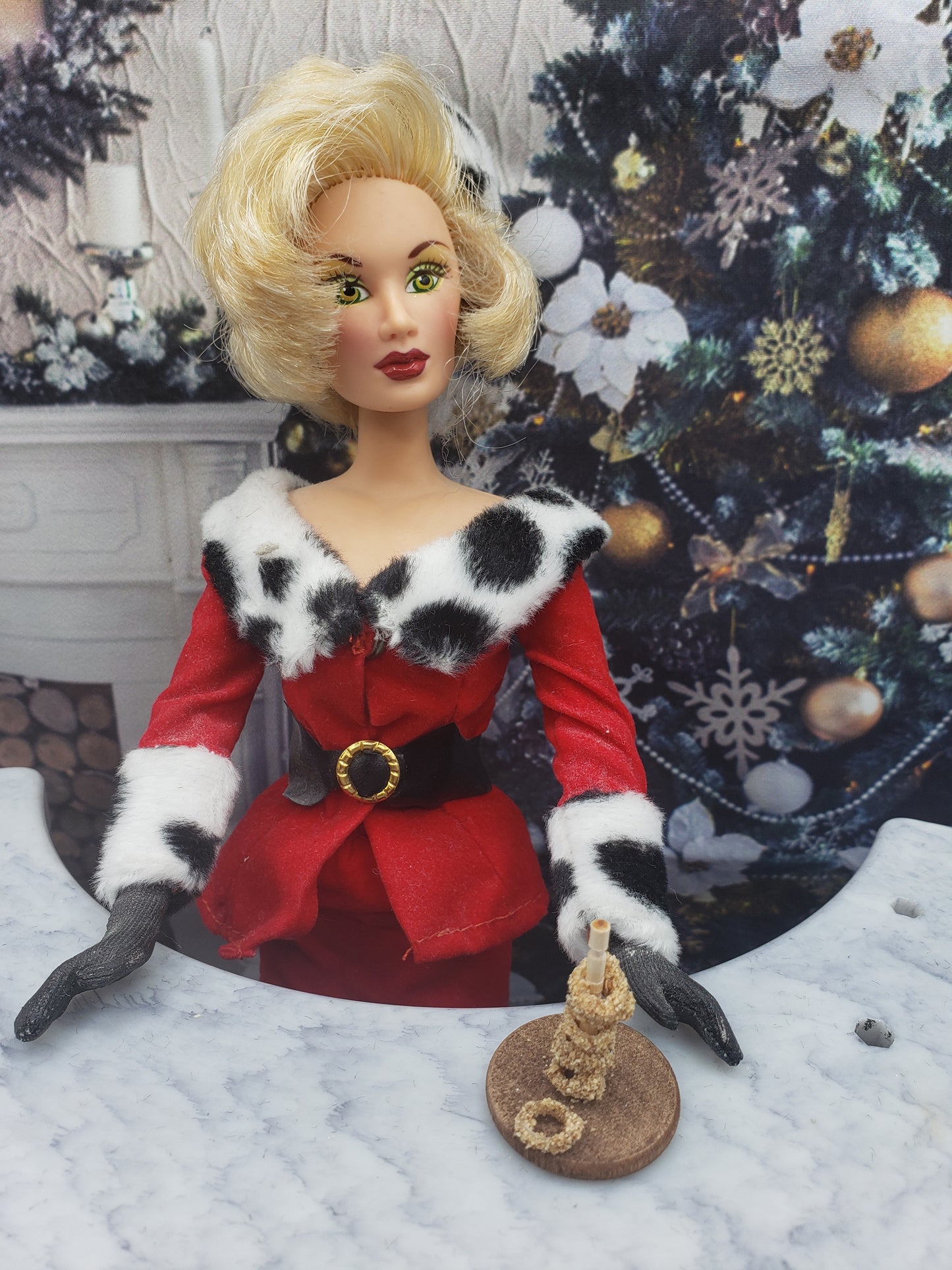 Miniature onion rings for dolls displayed on a small plate held by a doll in festive red and black outfit
