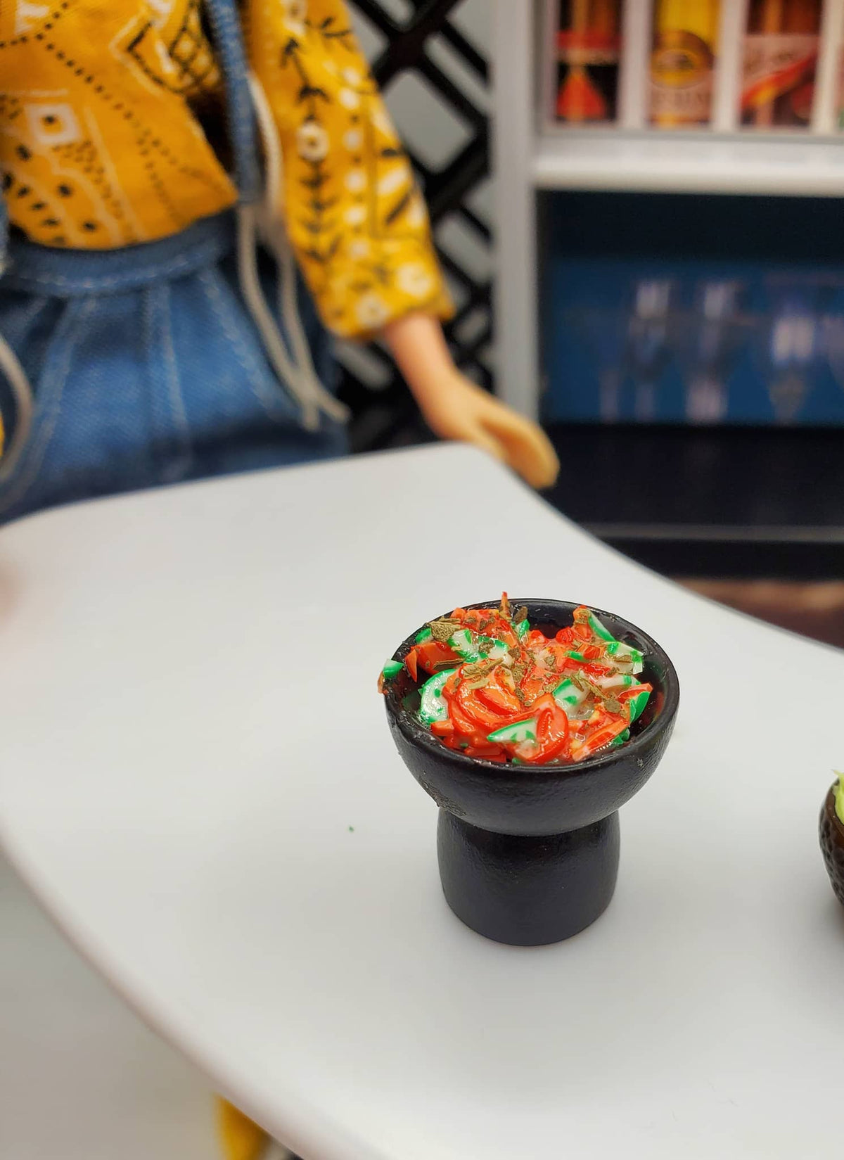 Chef Ginas miniature salsa for dolls in small black bowl on table with doll background