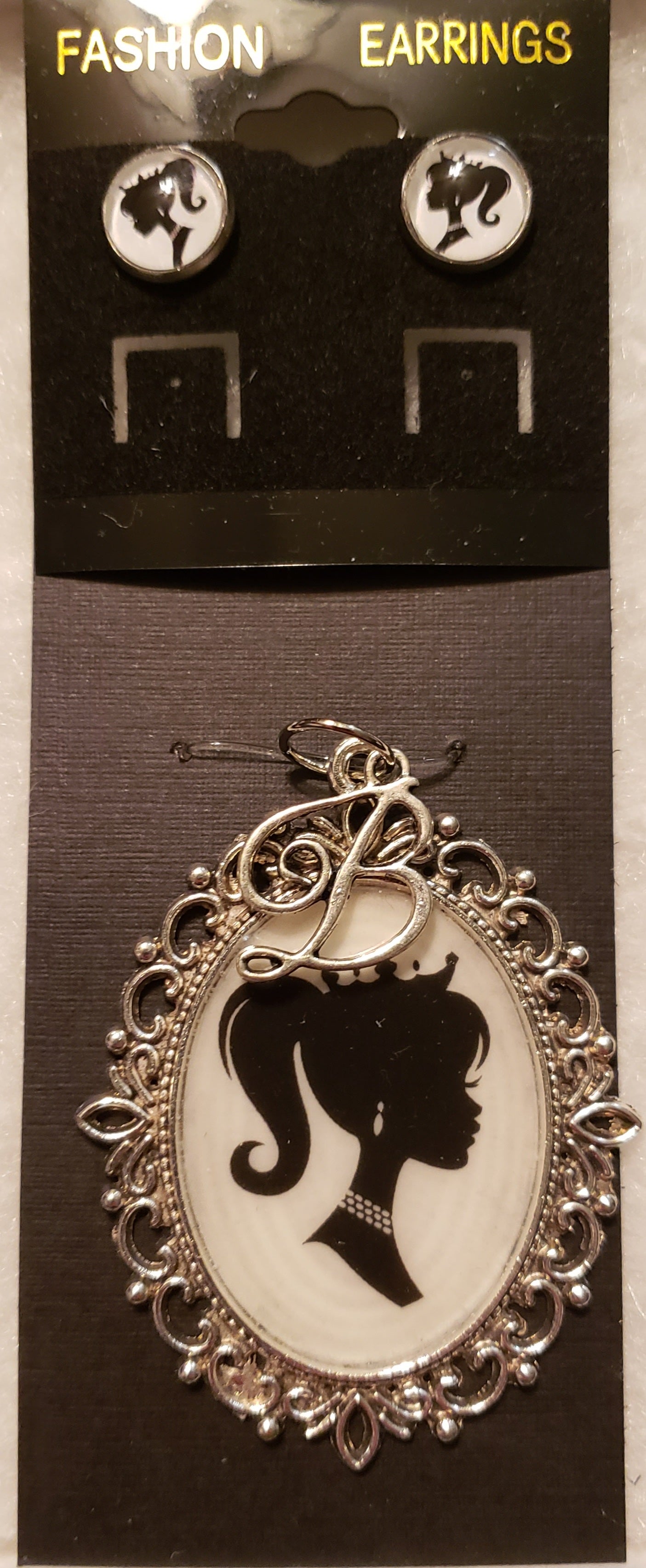 Barbie necklace set with silver pendant featuring Barbie silhouette and matching stud earrings