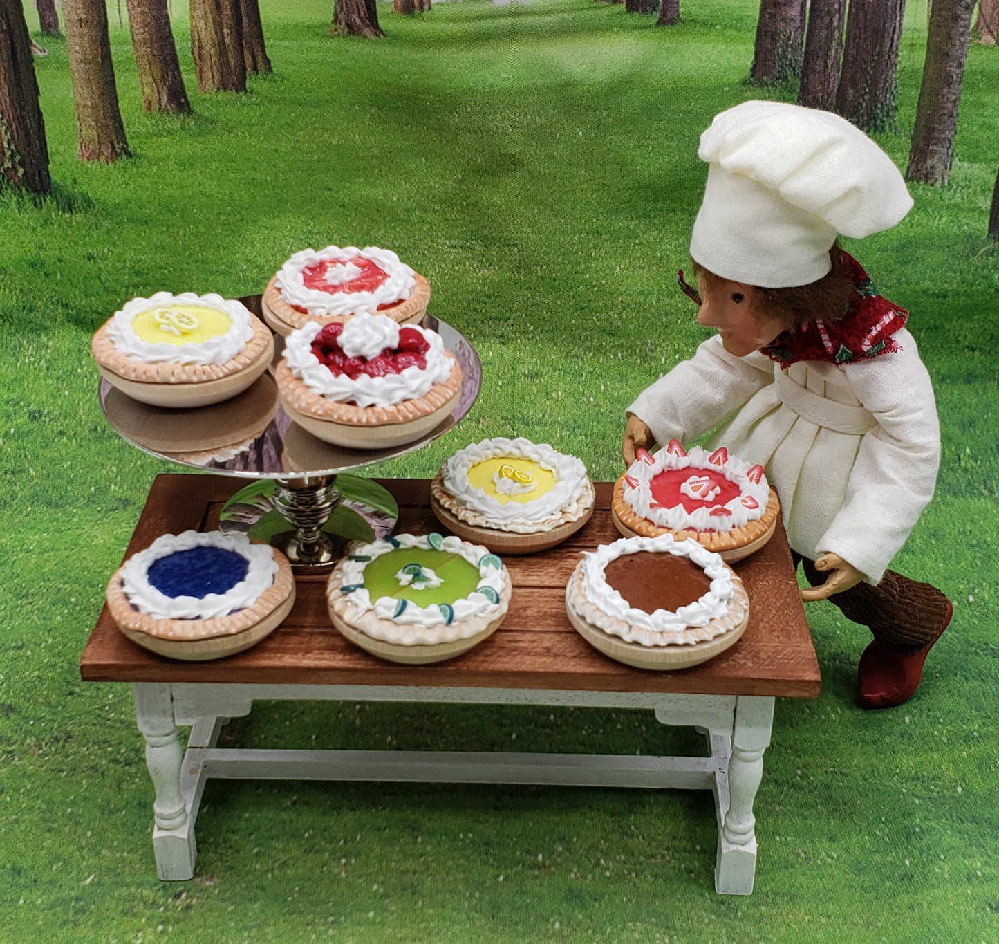 Miniature banana cream pie among colorful decorated pies on a wooden table outdoors