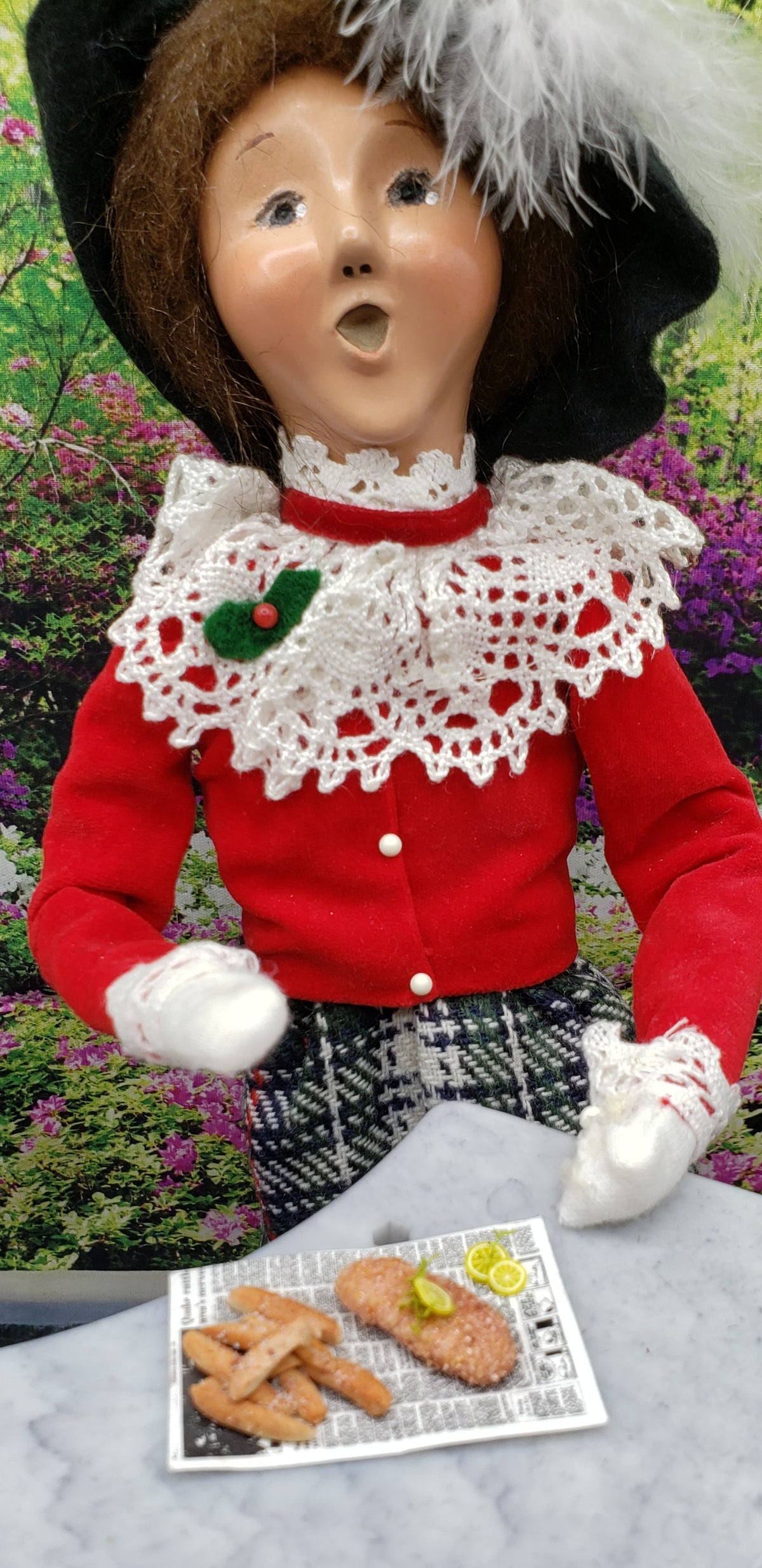 Chef Ginas Mini Food miniature fried fish for dolls displayed with a dressed doll in a vibrant garden setting