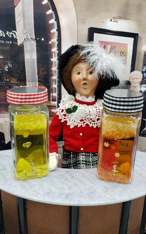 Miniature ice tea dispenser featuring two colorful jars for stylish beverage serving