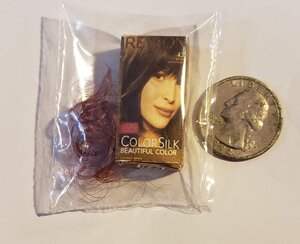 Revlon cornsilk brown doll accessory packaged with a quarter for size reference