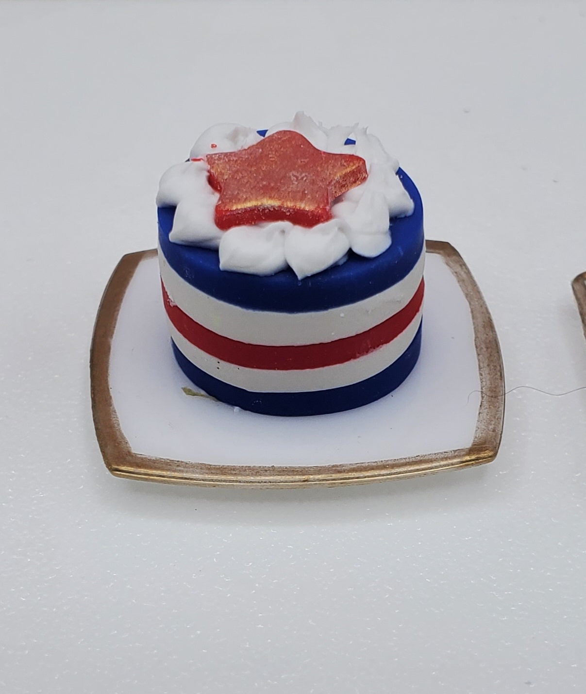 Small cake with red, white, and blue colors on a white plate.