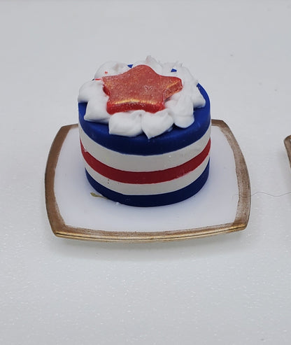Small cake with red, white, and blue colors on a white plate.