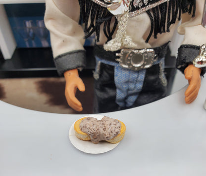 Chef Gina's miniature biscuits and gravy for dolls on a small plate in front of a doll dressed in western attire
