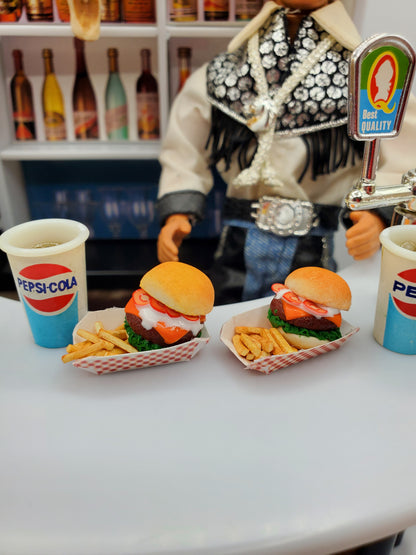 Chef Gina's miniature bison burgers for dolls served with fries and Pepsi-Cola cups on a table