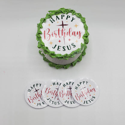 Decorative cake with 'Happy Birthday Jesus' text and matching coasters on a white background